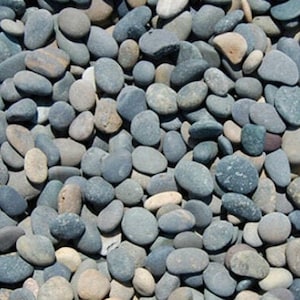 May include: A close-up of a collection of smooth, gray and black river rocks. The rocks are various sizes and shapes, and they are arranged in a random pattern.
