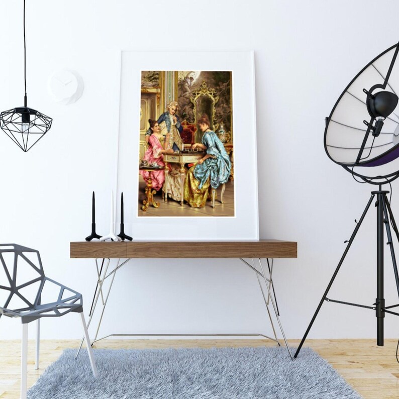 Rococo chess game print framed on a console table next to a tripod lamp; frame not included.
