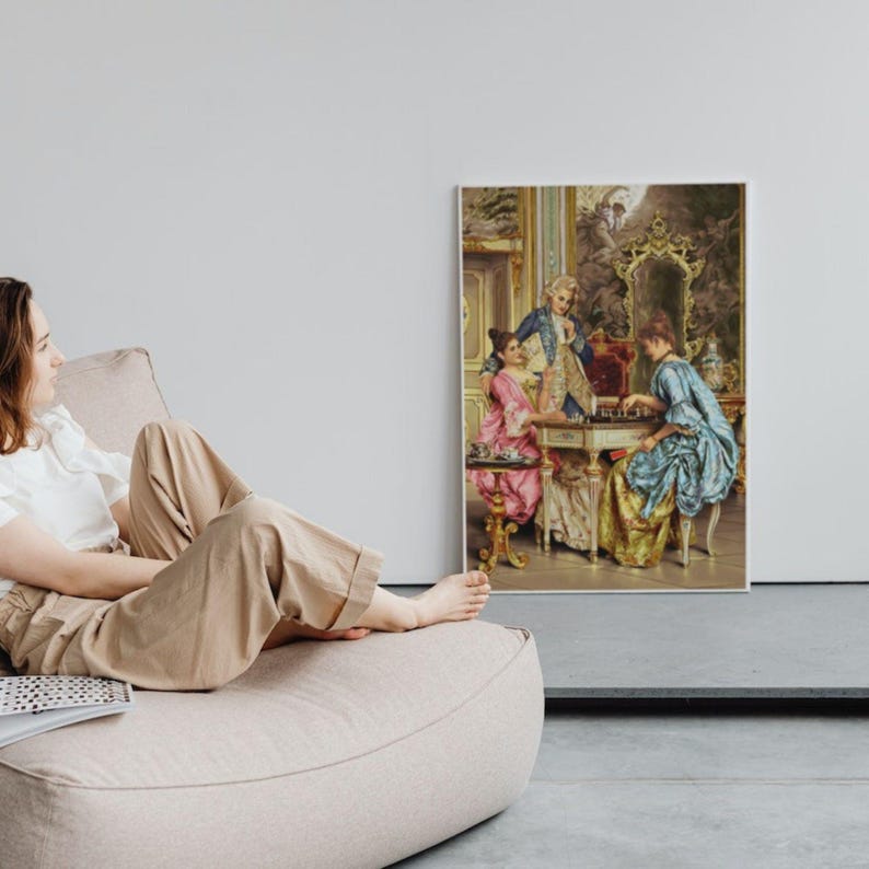Framed classical chess painting above a woman relaxing on a floor cushion; frame not included.