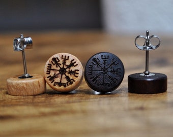 May include: A pair of circular stud earrings featuring a light wood and a dark wood piece. Each earring is engraved with a black Vegvisir symbol. The earrings include silver-toned metal posts and butterfly backings for secure attachment to the ear.