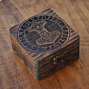 Mjolnir en runen. Doosje van dennenhout met de hamer van Thor erop gegraveerd, omgeven door runen. Speciaal doosje voor Noordse runen. Decoratie