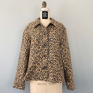 May include: A brown and black leopard print jacket with a button-up front and long sleeves.
