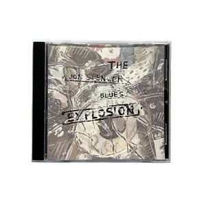 Op de afbeelding: Een cd-hoesje met het album "The Jon Spencer Blues Explosion". De cover is een getextureerde grijswaardenafbeelding met de bandnaam en albumtitel in een verweerde lettertype. De cd-hoes is zwart.