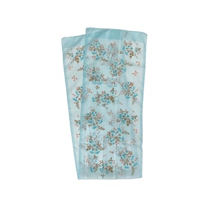 May include: A light blue silk scarf with a floral pattern in shades of brown and pink. The scarf has a delicate, flowing design and is perfect for adding a touch of elegance to any outfit.