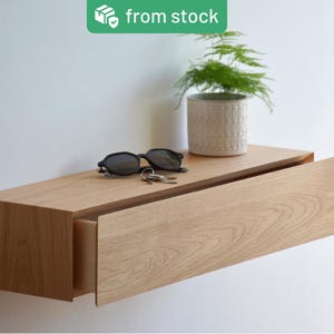 Floating entryway storage with a hidden drawer, made of solid oak