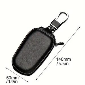 Puede incluir: Porta llaves de cuero negro con cierre de cremallera y gancho de metal plateado. El porta llaves mide 140 mm de largo y 50 mm de ancho.