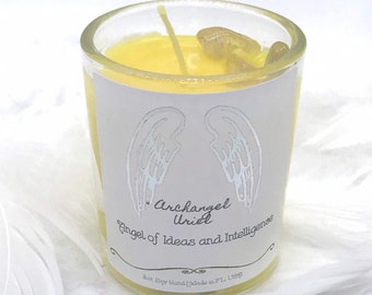 May include: A white candle jar with a yellow soy wax candle inside. The jar has a label with silver wings and the text "Archangel Uriel Angel of Ideas and Intelligence".