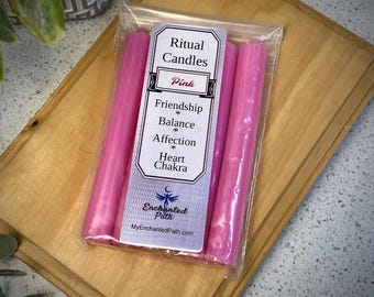 Pode incluir: Um pacote de quatro velas rituais cor-de-rosa com o texto "Ritual Candles Pink Friendship Balance Affection Heart Chakra" e o logotipo "Enchanted Path" com o site "MyEnchantedPath.com".