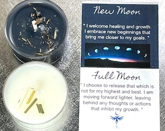 May include: Two white tea light candles with a black and white card. The card has the text "New Moon" and "Full Moon" with quotes about the moon phases. The candles have dried herbs and flowers inside.
