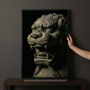 May include: A framed print featuring a detailed sculpture of a mythical lion-like creature. The artwork is predominantly gray and brown, with intricate carvings and a fierce expression. The background is black, enhancing the focus on the sculpture.