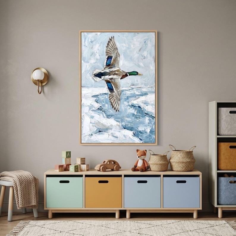 Textured winter mallard duck wall art above a storage unit with colorful bins, baskets, and wooden toys in a modern nursery.