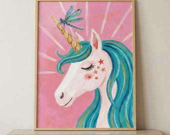 May include: A framed print of a unicorn with blue hair and a golden horn, adorned with a dragonfly. The unicorn has closed eyes and red star accents on its cheek, set against a pink background with white rays.