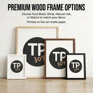 a collection of four framed artworks, each with a different wood frame color and size, arranged on a wooden floor against a white wall.
