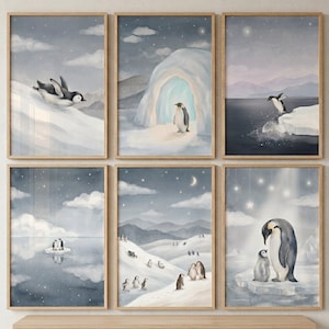 May include: Six framed watercolor prints featuring penguins in a snowy landscape. The artwork depicts penguins sliding, jumping, and interacting in a winter environment. The color palette includes shades of blue, gray, and white.