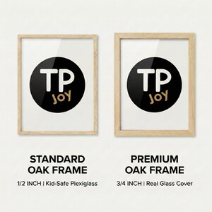 Side-by-side comparison of two oak wood frames featuring the “TP JOY” logo in a black circle. The left shows a standard 1/2 inch frame with kid-safe plexiglass, while the right displays a premium 3/4 inch frame with a real glass cover.