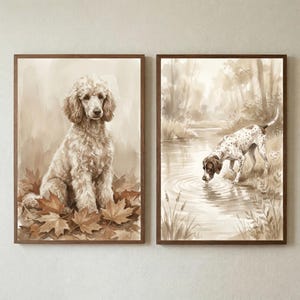 May include: Set of two framed sepia-toned dog art prints. One features a poodle sitting among autumn leaves. The other depicts a dog drinking from a pond in a forest setting. Both prints have brown wooden frames.