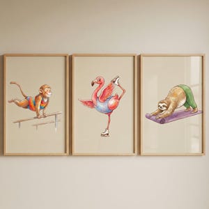 May include: Three framed wall art prints featuring watercolor illustrations of animals. The first shows a monkey on parallel bars, the second a flamingo wearing ice skates, and the third a sloth performing yoga on a purple mat.