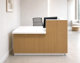 Puede incluir: Un mostrador de recepción con una encimera rectangular blanca y un panel frontal de listones de madera clara verticales. El escritorio incluye un monitor de ordenador negro y una silla de oficina de malla gris tras la superficie.