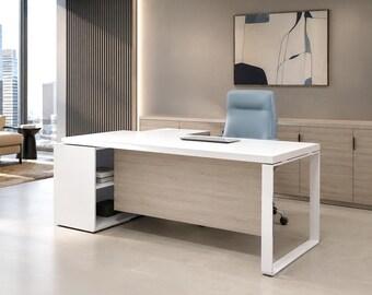 Puede incluir: Un escritorio ejecutivo blanco y de madera clara con una superficie rectangular, una unidad de almacenamiento lateral con dos estantes abiertos y una estructura de metal blanco. Una silla de oficina azul claro se sitúa tras el escritorio.