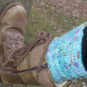 Puede incluir: Bota de cuero marrón con cremallera y cordones. La bota se lleva con un calienta piernas de punto azul y blanco.