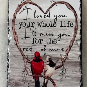 May include: A rectangular slate plaque with a heart-shaped branch design and the words "I loved you your whole life I'll miss you for the rest of mine." Two birds, one red and one white and black, perch on a branch.