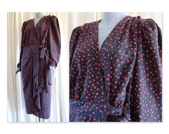 Puede incluir: Un vestido negro de envoltura con estampado floral rojo y mangas largas. El vestido tiene un escote en V y un lazo en la cintura.