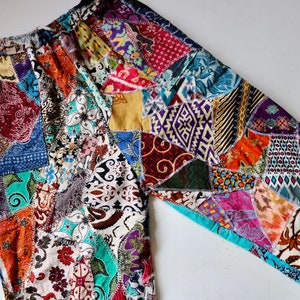 May include: Patchwork trousers made from a variety of colourful fabrics. The trousers are made from a variety of different patterns and colours, including red, blue, green, yellow, and purple.