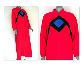 May include: A long, red dress with a mandarin collar and long sleeves. The dress features a black and blue geometric design on the chest. The dress is displayed on a mannequin.