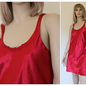 May include: A red satin slip dress with a delicate floral trim around the neckline.