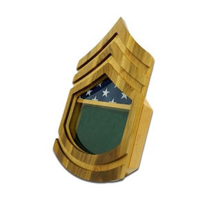 May include: Wooden shadow box with a glass front, featuring a carved American flag and a green felt background. The shadow box is shaped like a military rank insignia, with three stripes.