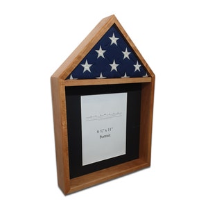May include: Wooden flag display case with a folded American flag in the top compartment and a 8 1/2" x 11" portrait frame in the bottom compartment.