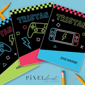May include: Notebooks with the name "Tristan" in neon green lettering. Each notebook features a different gaming theme, including a controller and a game console. The notebooks have a black background with colorful accents and the text "2ND GRADE".