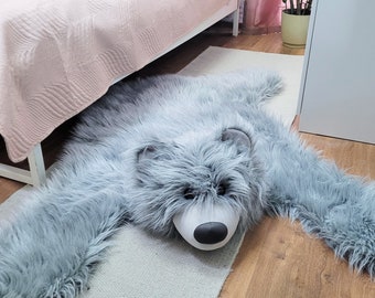 A teddy bear-shaped carpet for a child's room. Gray, furry teddy bear mat for the floor. Gray Rug for Baby Boy or Baby Girl. Forest motif