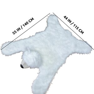 May include: White faux fur polar bear rug with a 55 inch by 44 inch measurement.