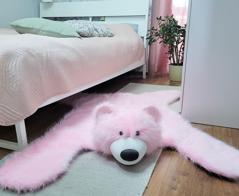 A sweet, shaggy carpet in the shape of a pink teddy bear. A floor mat for a little girl's room
