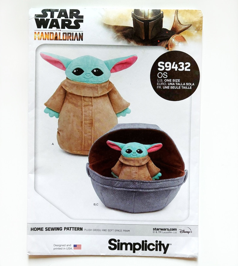 May include: A sewing pattern for a plush Grogu doll and a soft space pram from the Star Wars: The Mandalorian series. The pattern is from Simplicity and includes instructions for making a plush Grogu doll and a soft space pram. The pattern is for one size and is available in English, French, and Spanish.