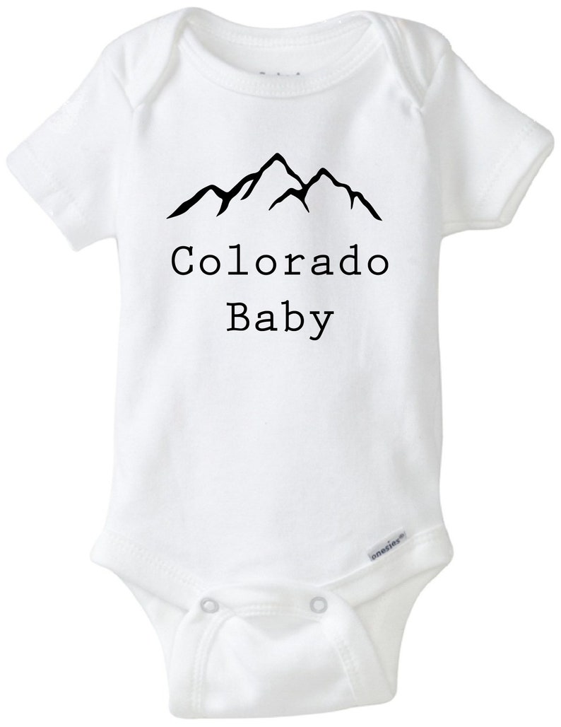 K&ouml;nnte beinhalten: Wei&szlig;er Baby-Strampler mit einem schwarzen Bergpanorama und dem Text "Colorado Baby".