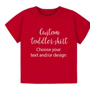 K&ouml;nnte beinhalten: Rotes T-Shirt f&uuml;r Kleinkinder mit wei&szlig;em Text, der "Custom toddler shirt Choose your text and/or design" lautet