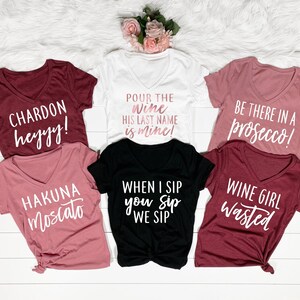 Puede incluir: Conjunto de seis camisetas con diferentes frases relacionadas con el vino. Las camisetas son de diferentes colores, incluyendo blanco, negro, rosa y granate. Las frases en las camisetas incluyen "Chardon heyyy!" "Hakuna Moscato" "&iexcl;Sirve el vino, su apellido es m&iacute;o!" "Cuando yo bebo, t&uacute; bebes, bebemos" "&iexcl;Est&eacute; ah&iacute; en un prosecco!" y "Chica del vino desperdiciada."