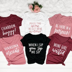 Puede incluir: Seis camisetas diferentes con frases humor&iacute;sticas sobre el vino. Las camisetas son de varios colores, incluyendo blanco, negro, granate y rosa.
