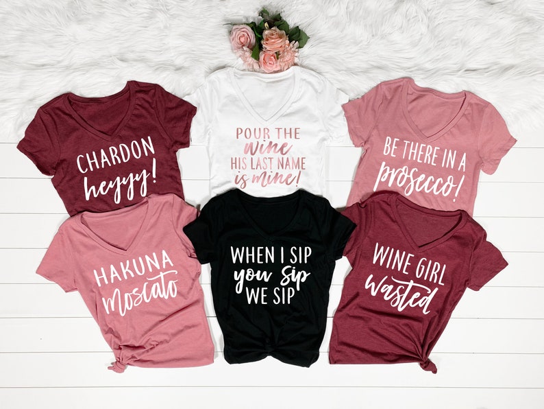 Puede incluir: Seis camisetas diferentes con frases humor&iacute;sticas sobre el vino. Las camisetas son de varios colores, incluyendo blanco, negro, granate y rosa.