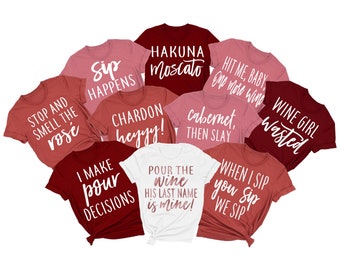 以下が含まれることがあります： 白文字で書かれた赤いTシャツとピンクのTシャツが10枚。Tシャツには、ワインをテーマにしたさまざまな言葉が書かれており、「Sip Happens」、「Hakuna Moscato」、「Hit Me Baby One More Wine」、「Wine Girl Wasted」、「Stop and Smell the Rose」、「Chardon Heyyy!」、「Cabernet Then Slay」、「I Make Pour Decisions」、「Pour the Wine His Last Name is Mine!」、「When I Sip You Sip We Sip」などがあります。