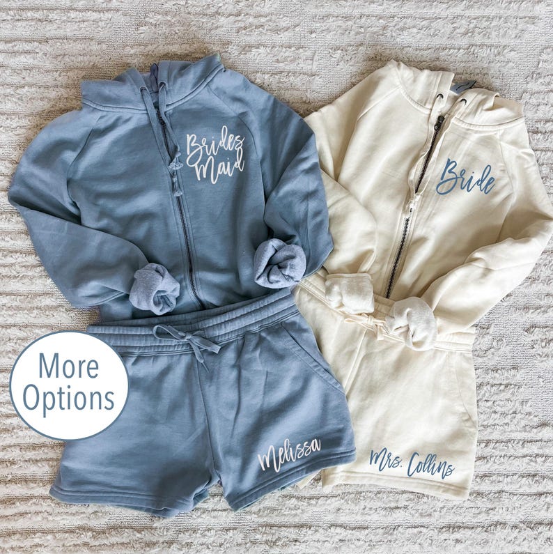 May include: Two matching blue and cream zip-up hoodies with the words "Bride" and "Bridemaid" embroidered on the front.  Matching blue sweatpants with the names "Melissa" and "Mrs. Collins" embroidered on the legs.