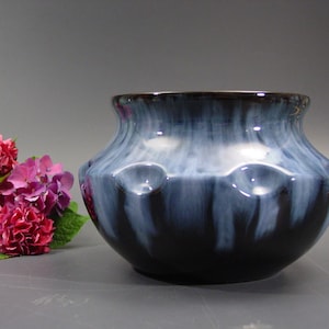 Op de afbeelding: Een blauwe en witte keramische vaas met een getextureerd oppervlak en een afgeronde vorm. De vaas heeft een glanzende afwerking en is versierd met een draaiend patroon.