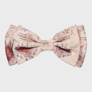 May include: A cream-colored bow tie featuring a map design with red and brown accents. The bow tie has text that reads "The Marauder's Map" and "Moony, Wormtail, Padfoot & Prongs".
