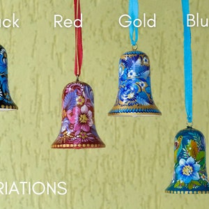 Puede incluir: Cuatro campanas de madera pintadas a mano con dise&ntilde;os florales. Las campanas son negras, rojas, doradas y azules. Las campanas cuelgan de cintas del mismo color que la campana. El texto "VARIATIONS" est&aacute; en la parte inferior de la imagen.