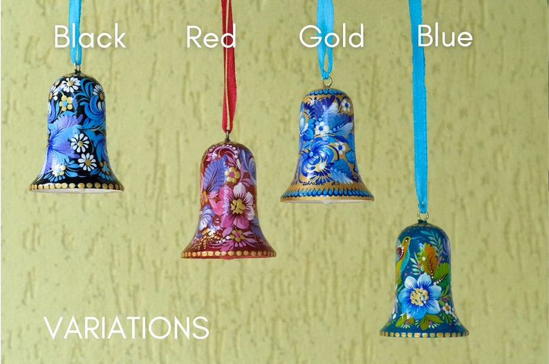 Puede incluir: Cuatro campanas de madera pintadas a mano con dise&ntilde;os florales. Las campanas son negras, rojas, doradas y azules. Las campanas cuelgan de cintas del mismo color que la campana. El texto "VARIATIONS" est&aacute; en la parte inferior de la imagen.