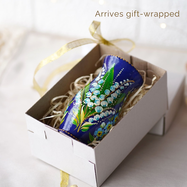 May include: A small blue and white hand-painted vase with a floral design, in a white gift box with shredded paper. Arrives gift-wrapped.