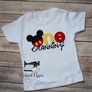 Peut inclure: T-shirt &agrave; manches courtes blanche avec un motif Mickey Mouse brod&eacute; en rouge, jaune et noir et le texte "one cranning".