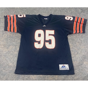 May include: Navy blue football jersey with the number 95 in white with an orange outline. The sleeves have orange and white stripes. The jersey has a V-neck and the Apex brand label.